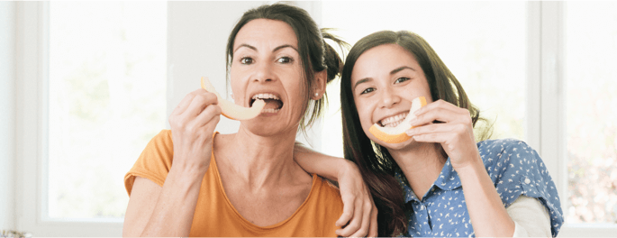 mother and daughter eating food together
